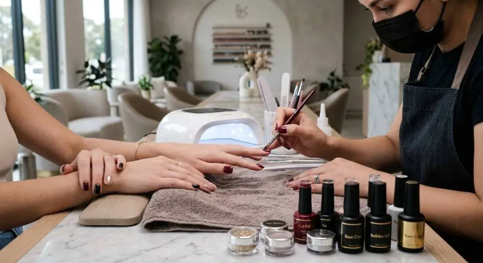 Professional nail technician applying a glossy gel manicure with Magpie Nails products.